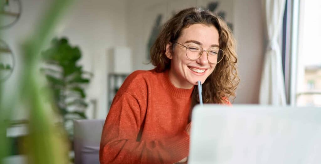 Photo of happy person working on a computer on one of our self-guided certificate programs
